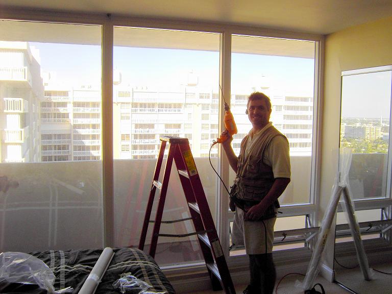 A picture of George preparing to install shades.